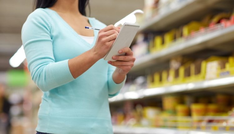 woman with notebook shopping at supermarket