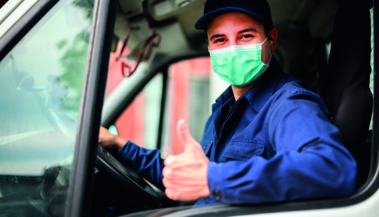 Portrait of a van driver giving thumbs up and wearing a mask, coronavirus concept