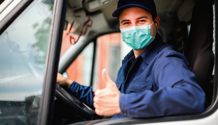 Portrait of a van driver giving thumbs up and wearing a mask, coronavirus concept